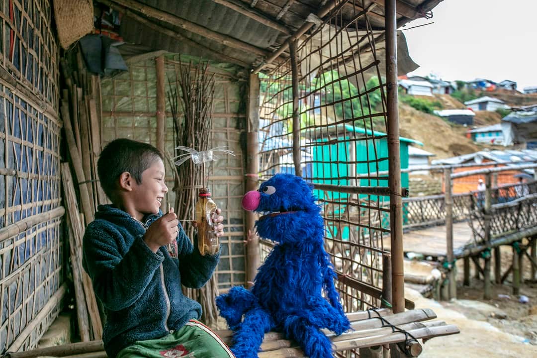 A youth plays with a Grover doll at a Rohingya refugee camp in Bangladesh.