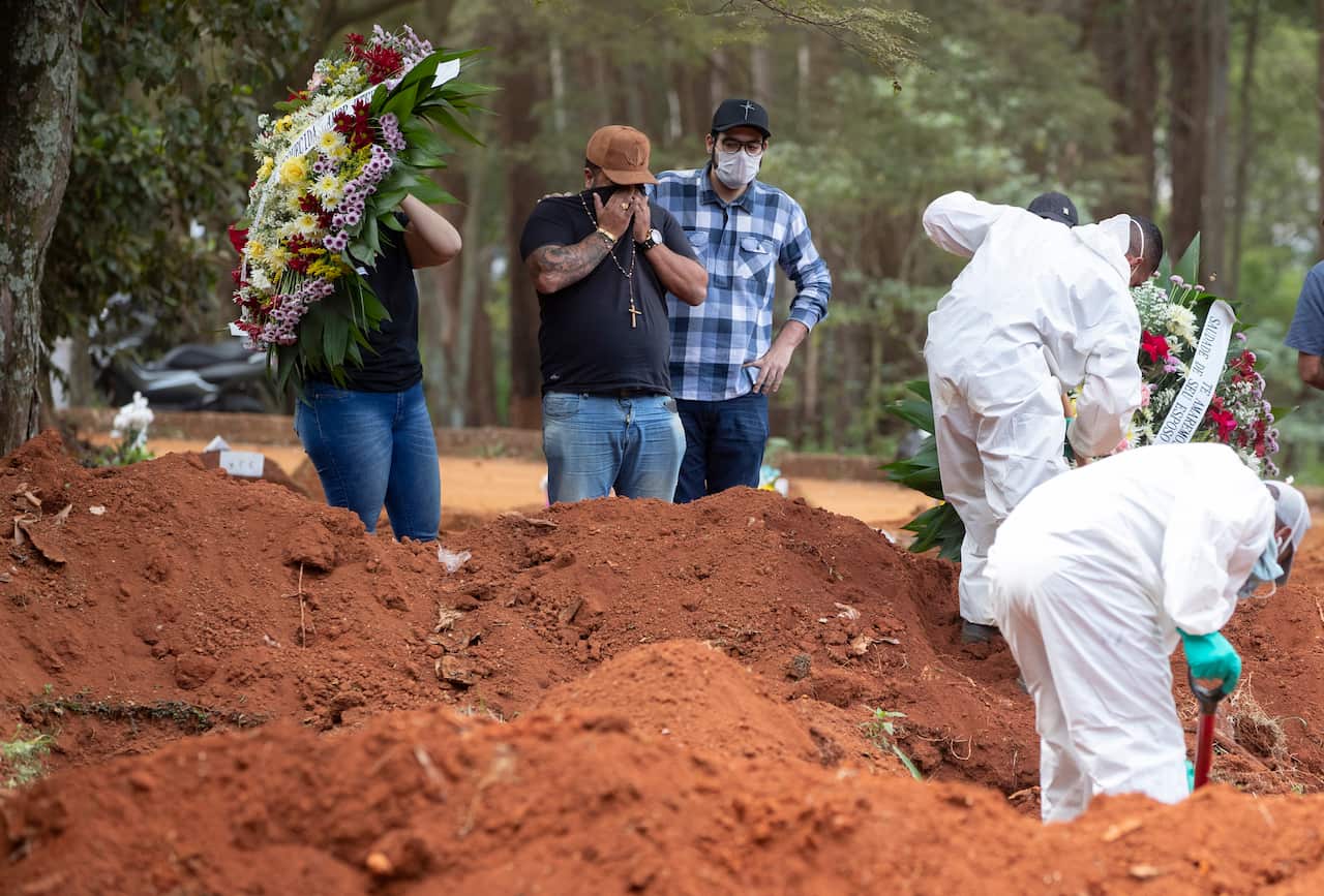 Rodrigo Fernando Silva, second from left, and relatives attends the burial of his 58-year-old mother Aparecida January Ferreira (AAP)