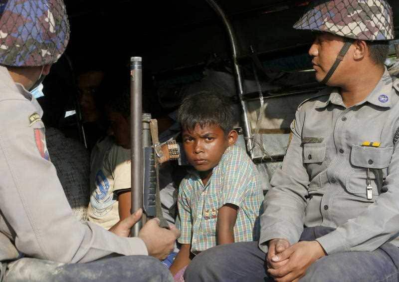 A boy looks from a police truck at the KyaukTan township, south of Yangon, Myanmar. More than 100 Rohingyas have been arrested on a shore in KyaykTan township.