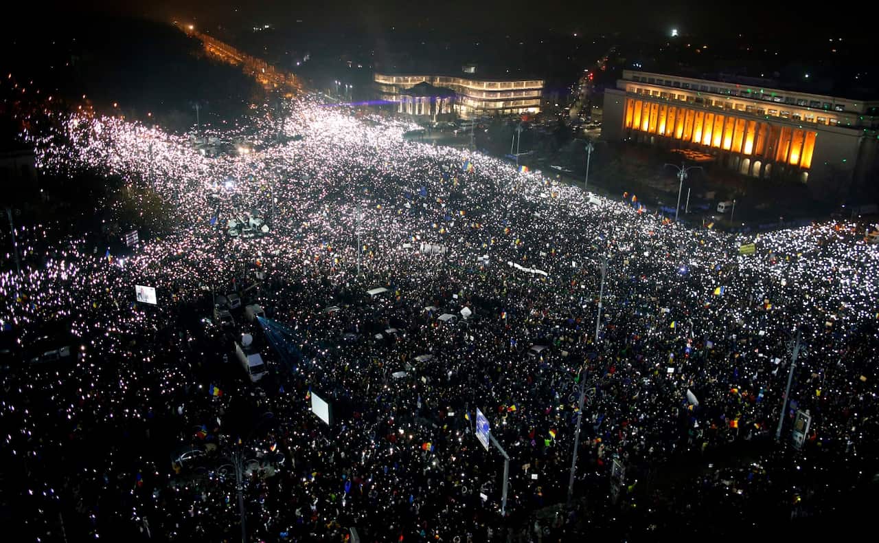 Tens of thousands of people gather for a demonstration in from of the government building in Bucharest, Romania, Sunday, Feb. 5, 2017. (AAP)