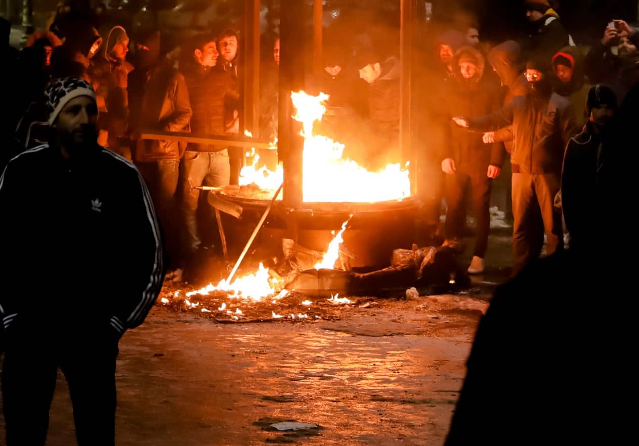 Protesters warm up next to a burning kiosk after minor clashes erupted during a protest in Bucharest, Romania, Thursday, Feb. 2, 2017. (AAP)