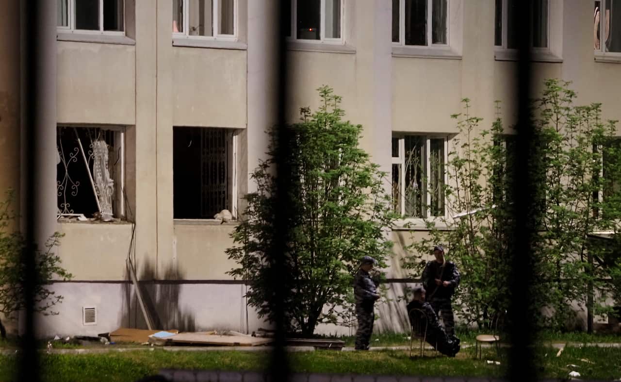 Police officers guard near a school after a shooting in Kazan, Russia, Tuesday, May 11, 2021.