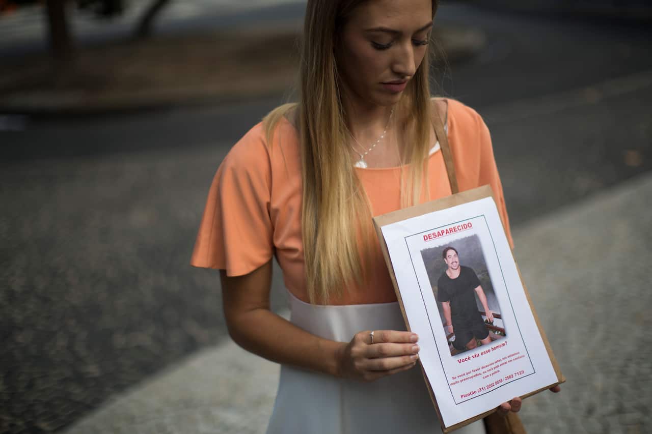 Bonnie Cuthbert, of Australia, shows a photo of her missing boyfriend Rye Hunt, 25, during a press conference in Rio de Janeiro, Brazil on Friday