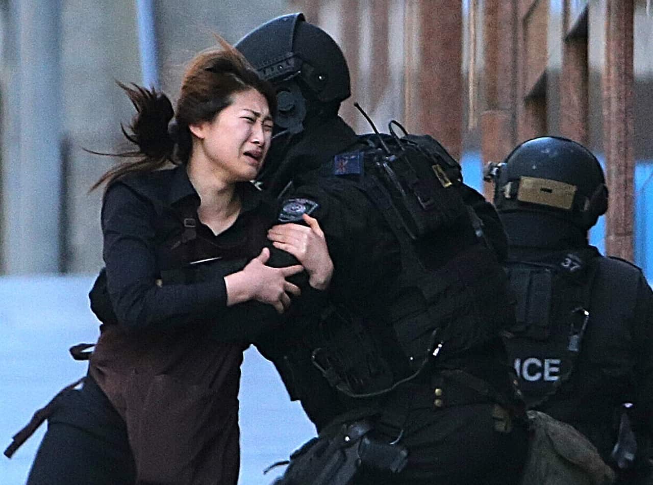 The image that will remain with Australia for years to come. A women runs into the arms of police after a gunmen had been holding people hostage since before 10 o'clock on 15 December . The Sydney siege ended on December 16 at 2am after gun shots were hea