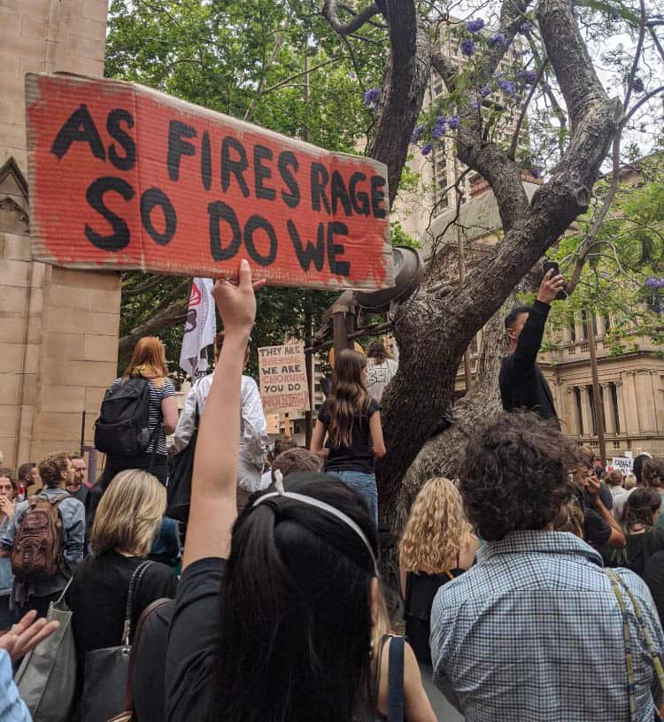 People hold up signs as they rally outside Sydney Town Hall.