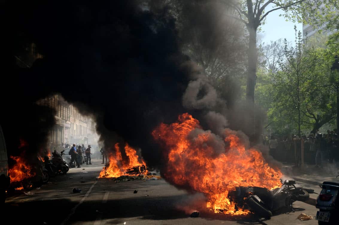Scooters are seen burning on a street as thousands of protesters from the 'Gilets Jaunes' (Yellow Vests) movement clash with French riot Police (AAP)