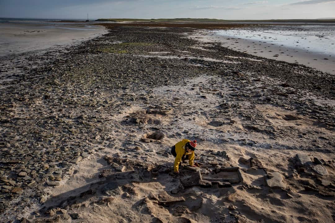 Jane Downes works at an archaeological site on Sanday, one of the Orkney Islands in Scotland.