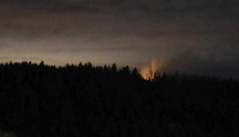 Flames pour from the crash site.