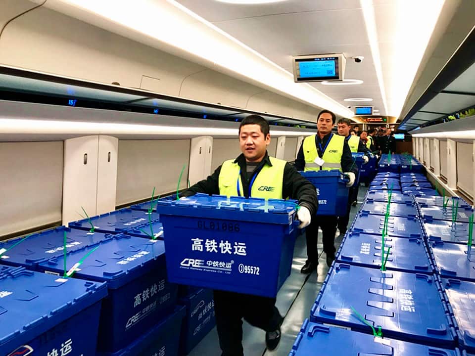 Chinese workers carry goods from Singles' Day online shopping onto a "Fuxing" high-speed bullet train from Beijing to Changsha.