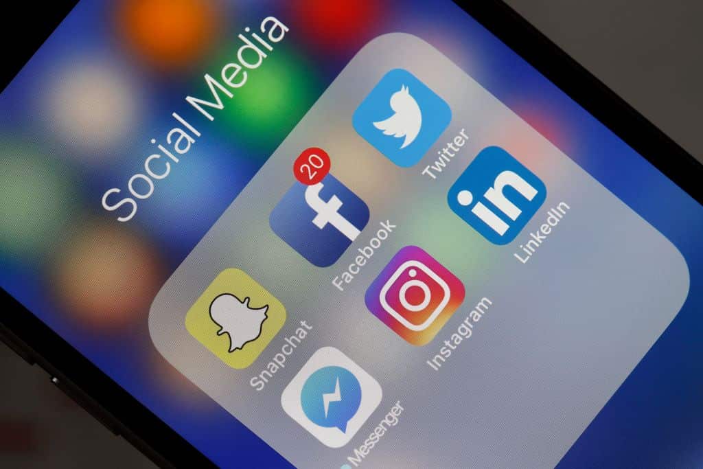  logos of the Snapchat, Facebook, Twitter, Messenger, Instagram and LinkedIn applications are displayed on the screen of an Apple iPhone. 