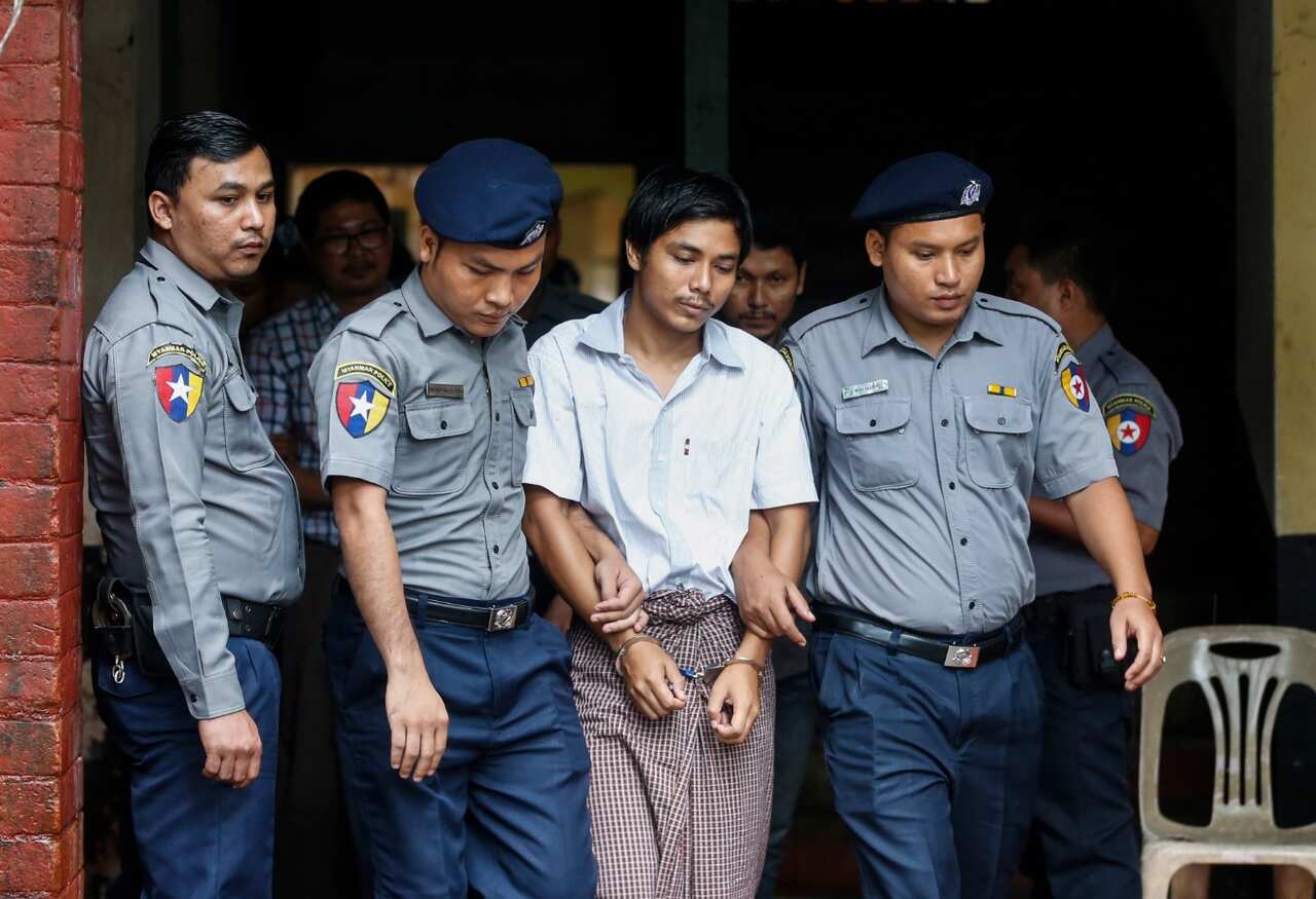 Detained Reuters journalist Kyaw Soe Oo, 28, is escorted by police as he leaves court during his trial.