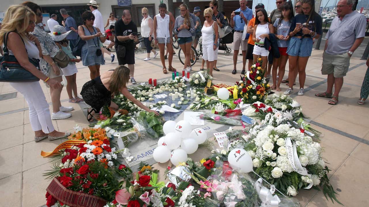 People lay flowers at a memorial plaque in memory of the victims of the Cambrils and Barcerlona terrorists attacks in 2017.