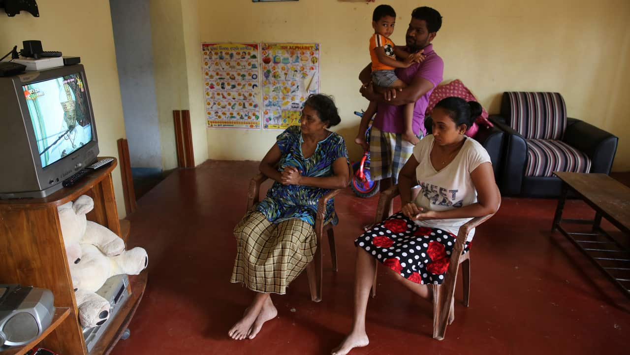 A Sri Lankan Christian catholic family watches and prays inside their home watching live transmission of Sri Lankan Archbishop Cardinal Malcolm Ranjith.