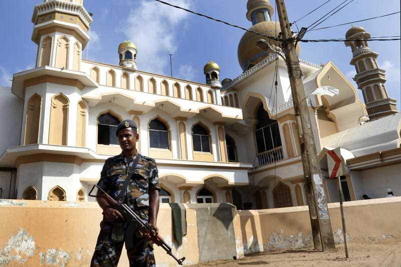  Sri Lankan security personnel stand guard after the clashes erupted between the two communities in Negombo near Colombo.