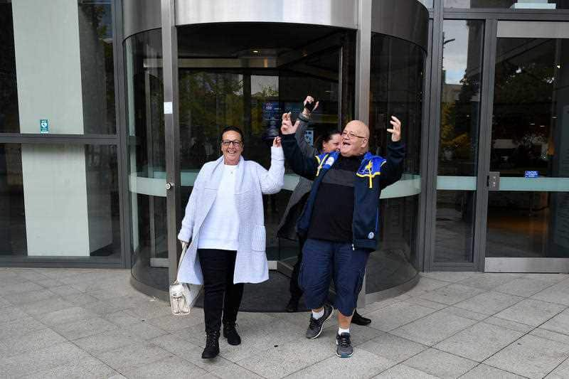 Victim Wayne Greenhalgh (right) and wife Bronwen Greenhalgh celebrate as they leave Parramatta Court.