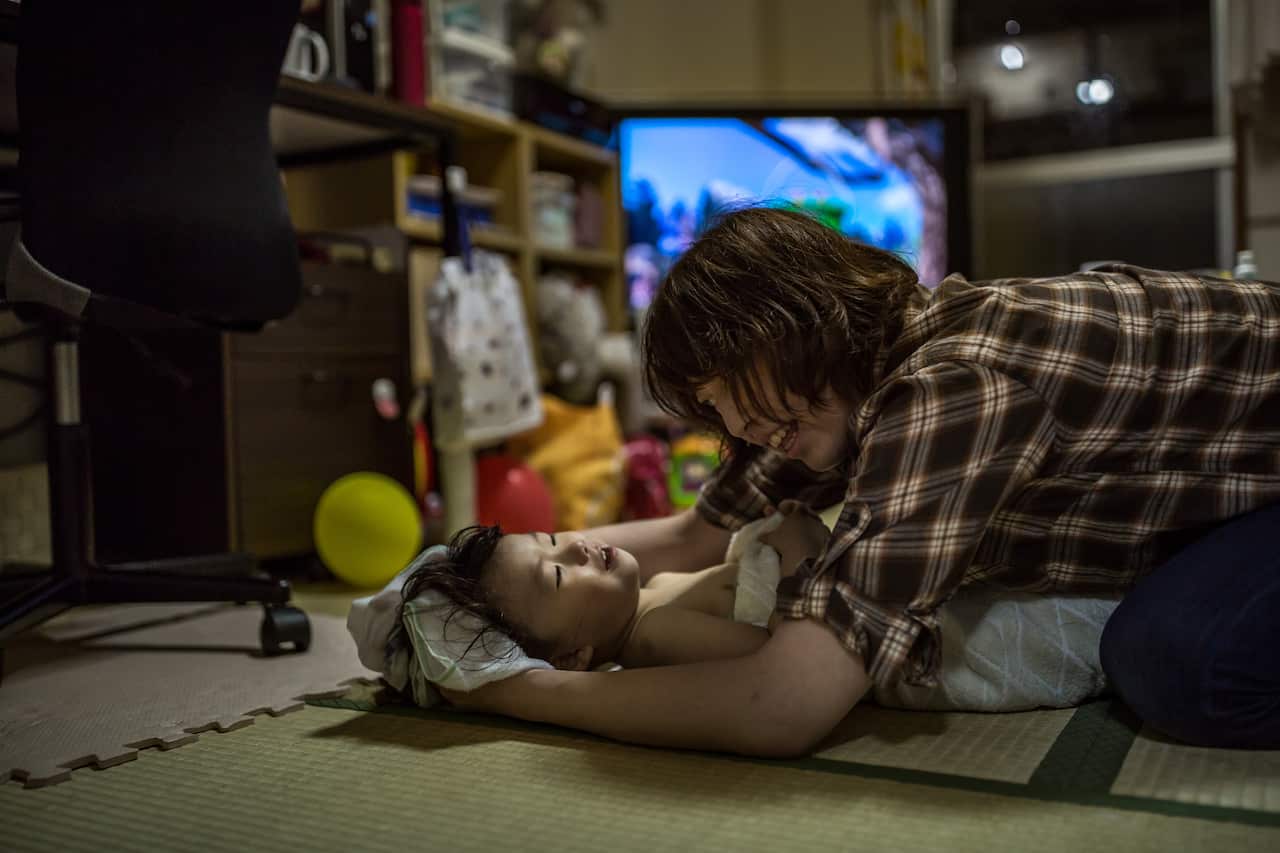 Erica Takato dries her daughters hair after her nightly bath, in Tokyo.
