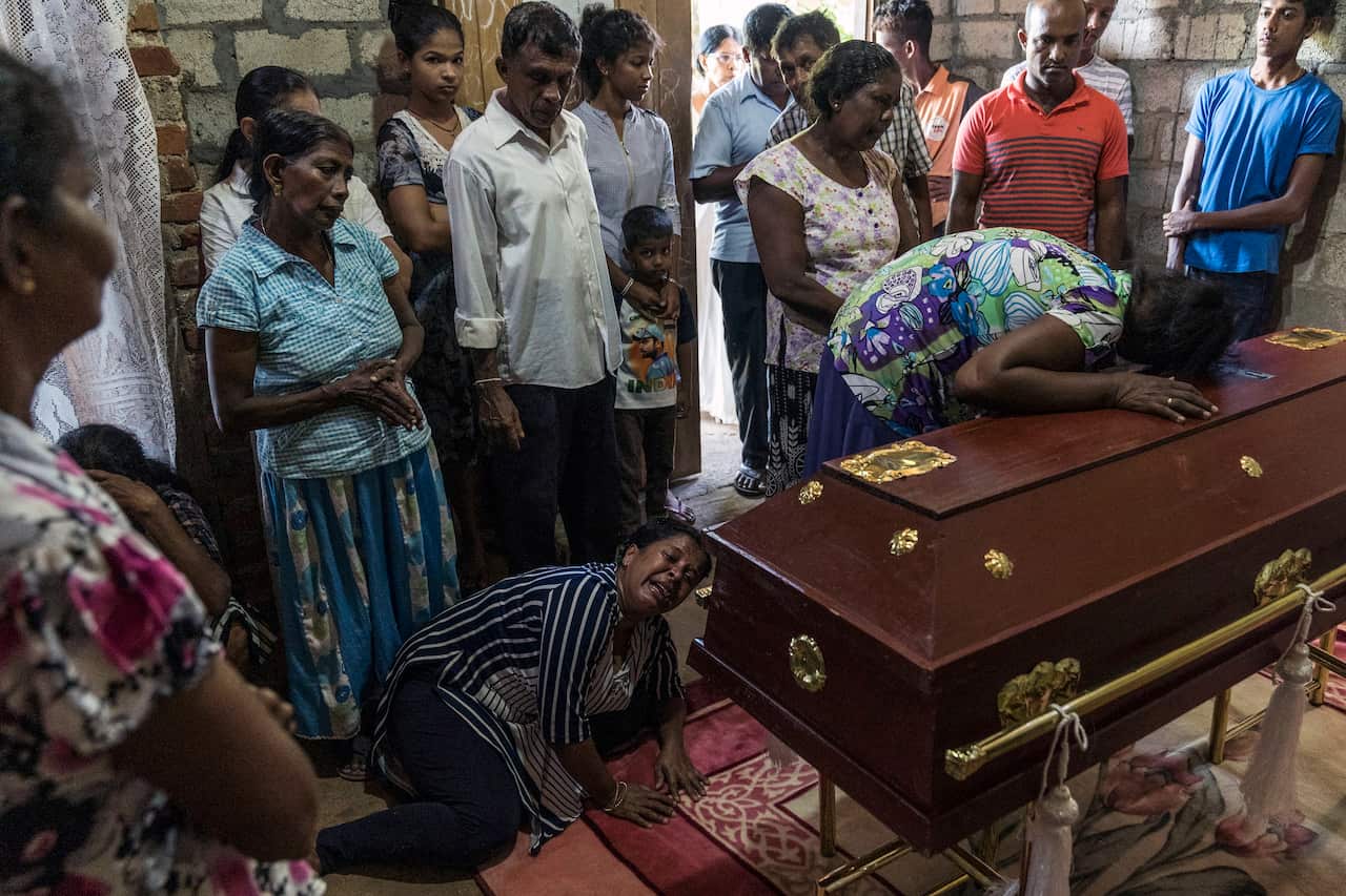 Relatives of Sneha Savindi, 11, mourn at her wake in Negombo, Sri Lanka, on Monday.