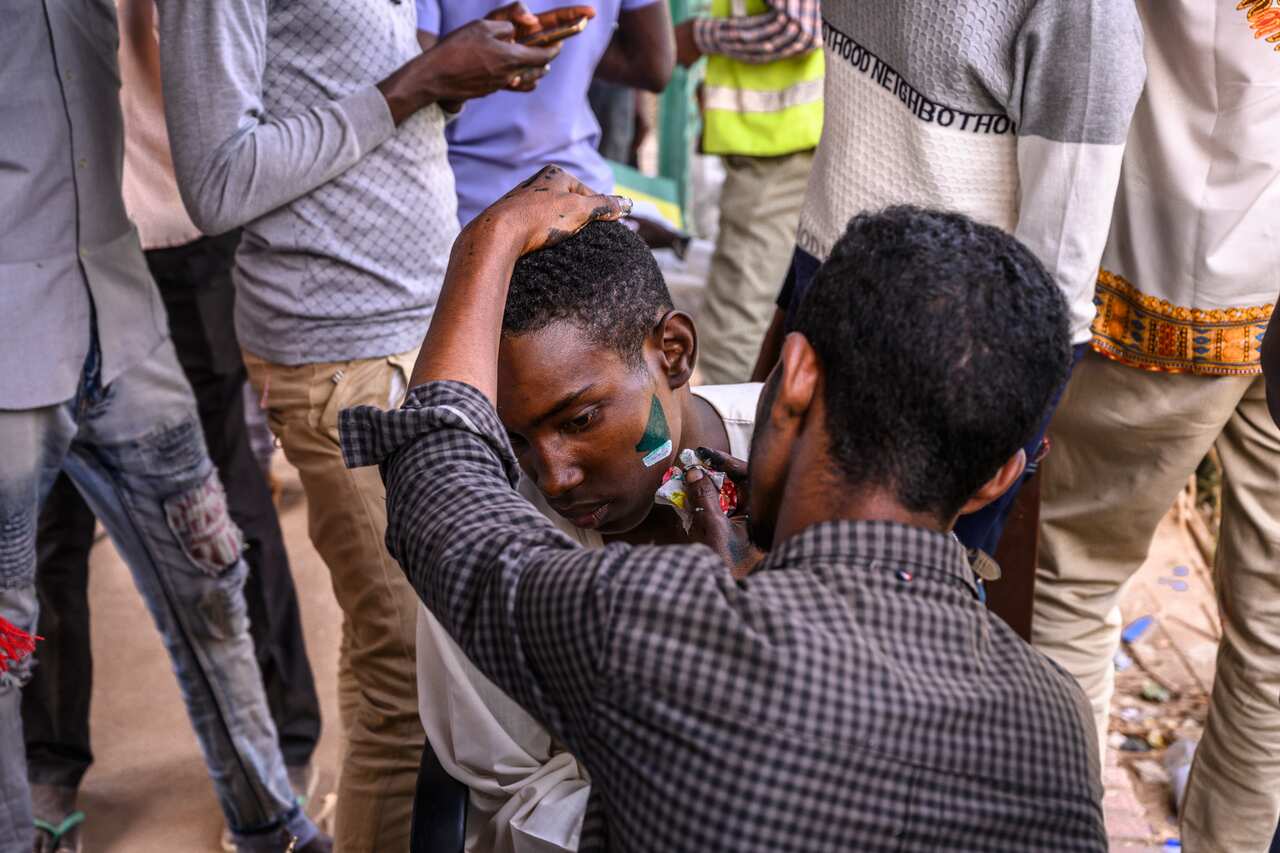 A protester has his face painted at the site of a sit-in in Khartoum, Sudan