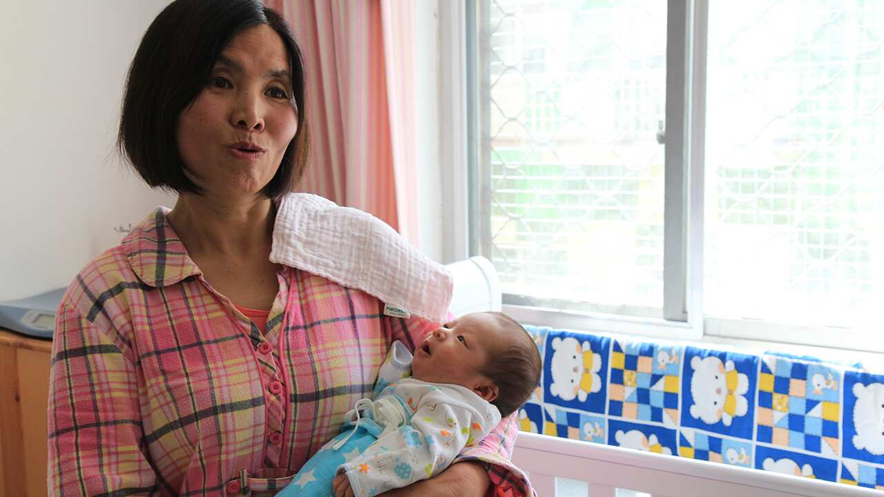 Ms Wen with Shasha's baby - she’s been caring for mums and their newborns for around seven years and has a long waiting list.