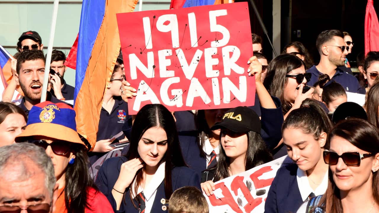 Protestors hold signs at the rally in Sydney.