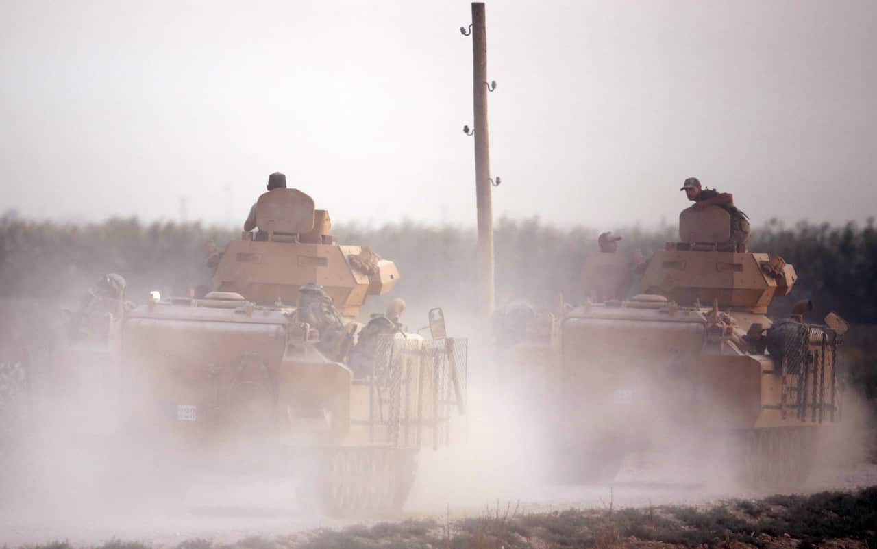 Turkish armored vehicles cross over into northern Syria as part of the attack.