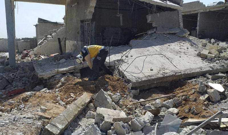 Syrians pick through the ruble following a strike in Ariha.