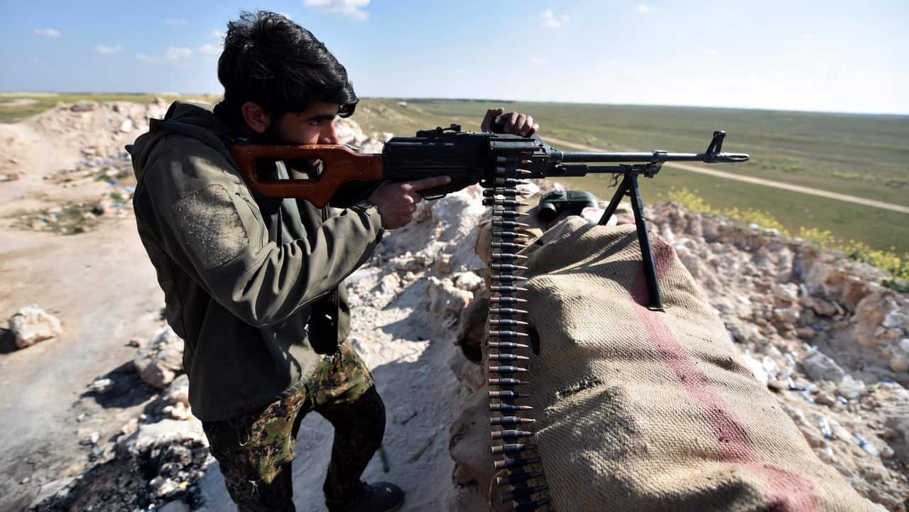 A member of US-backed Syrian Democratic Forces (SDF), stands guard against IS forces in Syria.