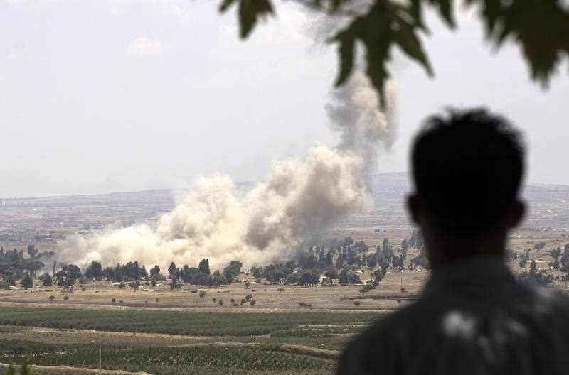 Smoke rises from the Syrian city of Quneitra. Israel said rebel forces had detonated ammunition stores before retreating from a massive regime offensive.