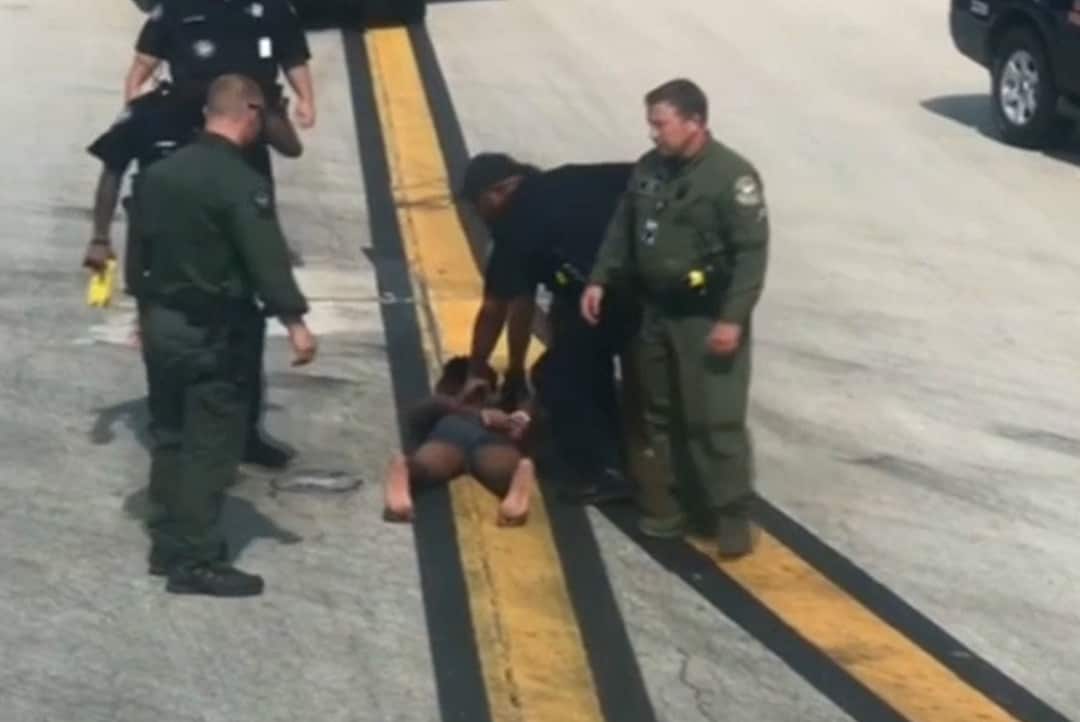 Police arrest the man at Atlanta airport on Tuesday.