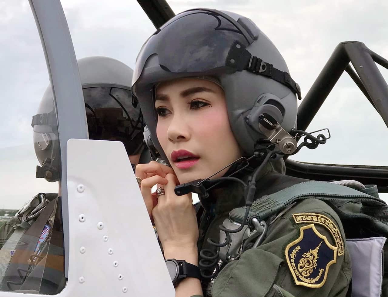 Thai royal noble consort Sineenat Wongvajirapakdi adjusting her pilot helmet in a military aircraft during training in Thailand.