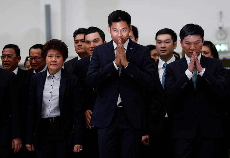 Thai Raksa Chart Party leader Preechapol Pongpanich performs a Thai greeting as he and the party's executive members arrive at the court ahead of the ruling.