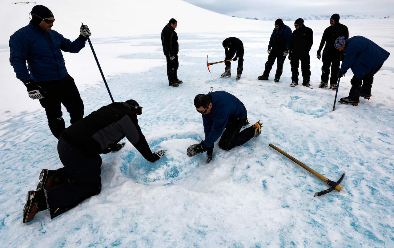 A group of explores extract blue ice blocks near the Glaciar Union camp in the Ellsworth Mountains, Antarctica, last year. 