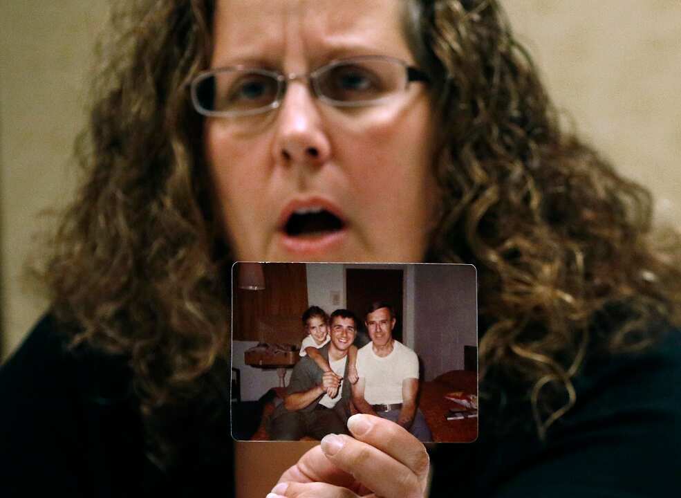 Alexa MacPherson, a victim of clergy sex abuse, holds a photograph of herself as a child.