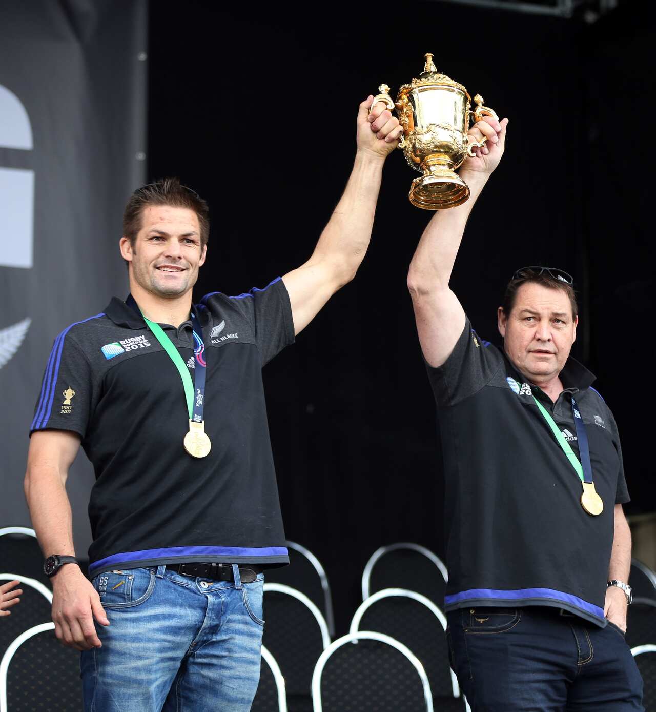 All Blacks captain Richie McCaw and coach Steve Hansen hold the Rugby World Cup trophy at a parade and official welcome for the New Zealand All Black rugby team in Auckland.