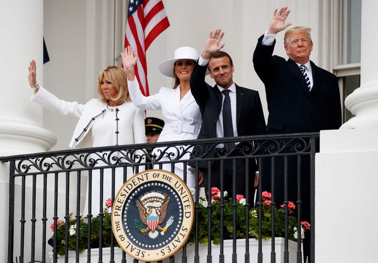 President Donald Trump, first lady Melania Trump, French President Emmanuel Macron and his wife Brigitte Macron wave from the Truman Balcony 