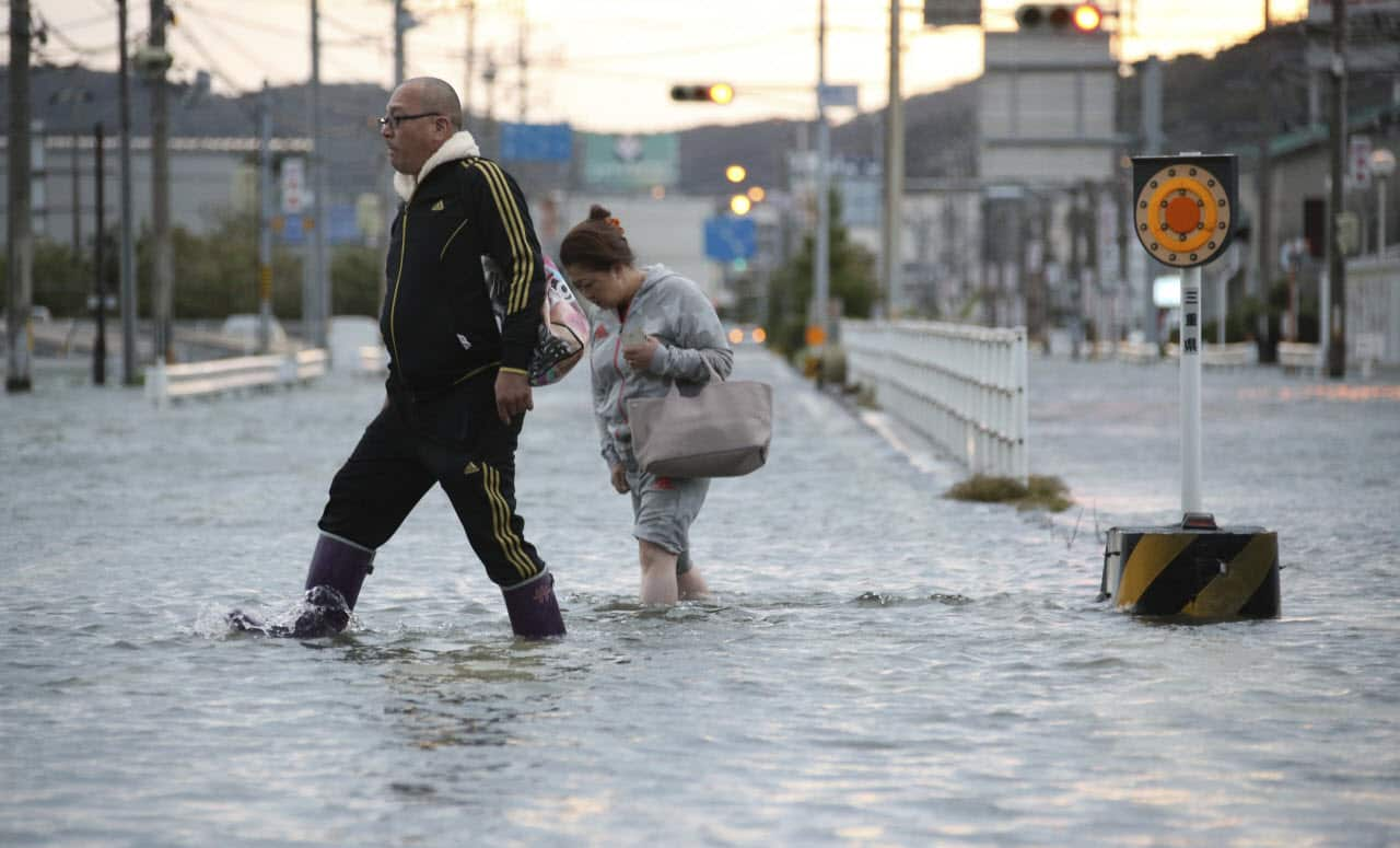  People walk on a water covered street in Ise City, Mie Prefecture on Oct. 23, 2017.