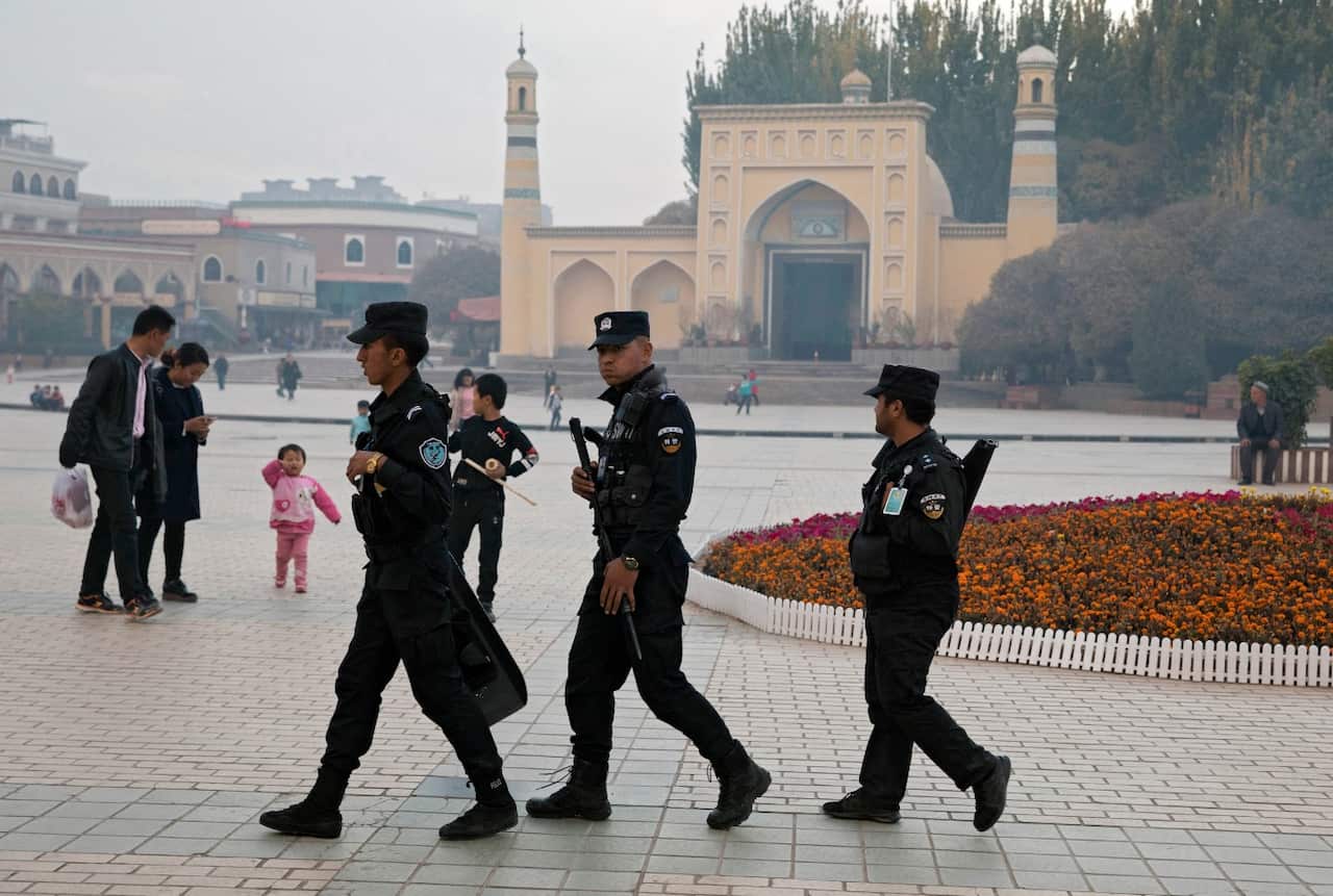 In this Nov. 4, 2017, file photo, Uighur security personnel patrol near the Id Kah Mosque in Kashgar in western China's Xinjiang region. 
