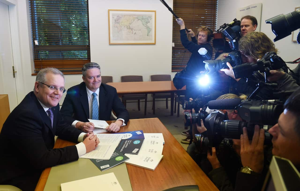 Treasurer Scott Morrison (L) and Minister for Finance Senator Mathias Cormann look at the Budget Papers on Tuesday