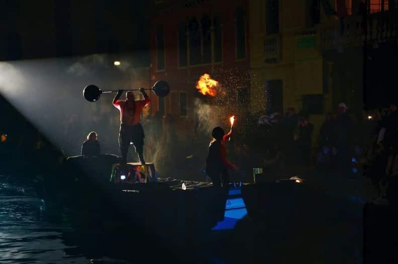 Circus performers hold up barbells and breathe fire as part of Venice Carnivale celebrations