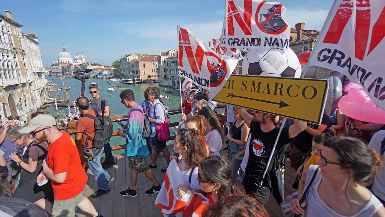 People march with the 'No Grandi Navi' flag, during a demonstration against cruise ships being allowed in the Lagoon of Venice.