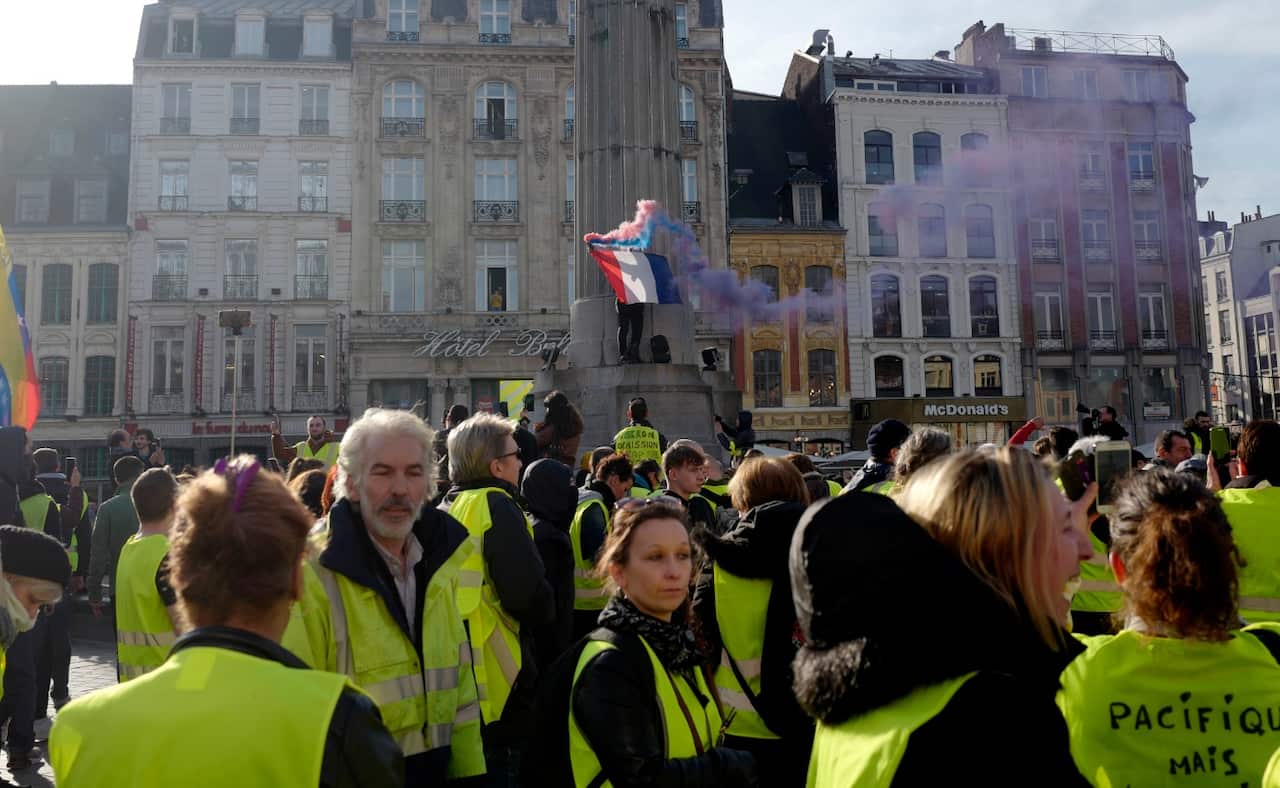 Yellow vest protester holds a French flag during a demonstration Saturday, Feb. 16, 2019, in Lille.