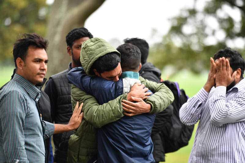 Friends of a missing man grieve outside a refuge centre in Christchurch.