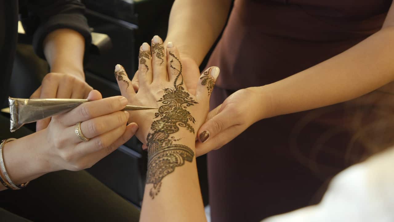 Fareha Ahmad creating a henna design for a client