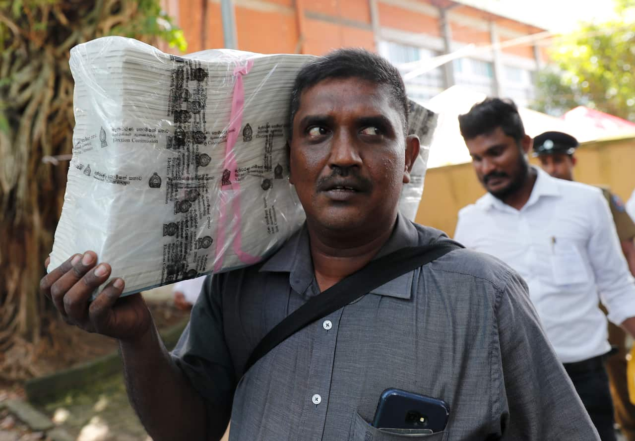 A Sri Lankan polling worker carries ballot papers outside a polling material distribution center in Colombo.