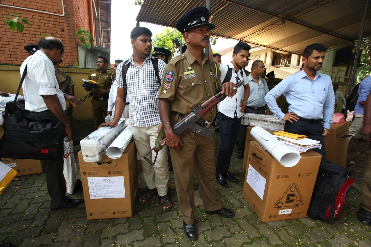 Security personnel escort Sri Lankan polling officers carrying election materials as they leave for their polling booths.