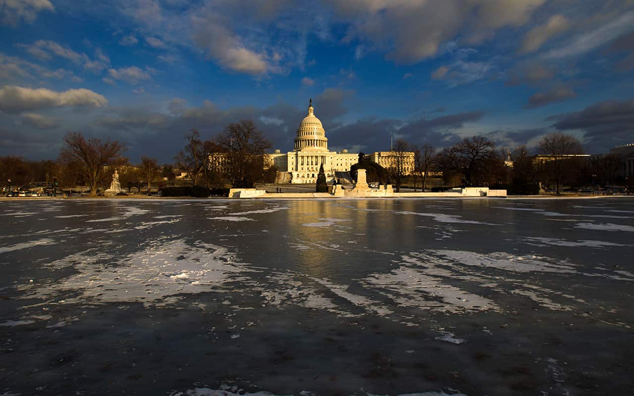 The US Capitol is seen with the frozen reflecting pool at sunset on Thursday, Jan. 4, 2018.