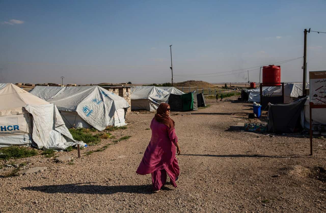 Sarah Ibrahim, 31, walks through a secure camp for the families of IS members, in Kurdish-controlled northern Syria, June 23, 2018.