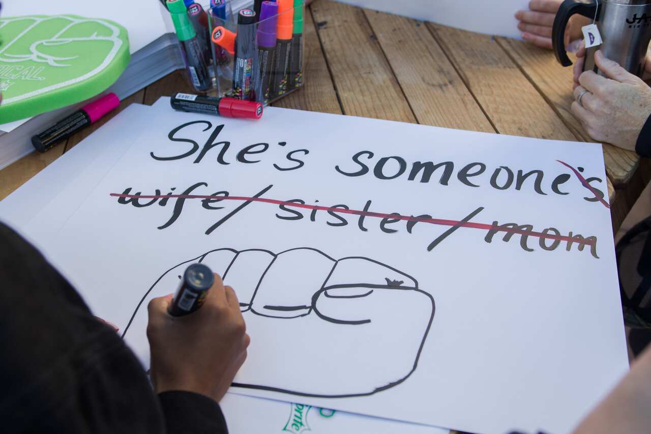 A demonstrator makes a poster during the Women's March in Los Angeles.