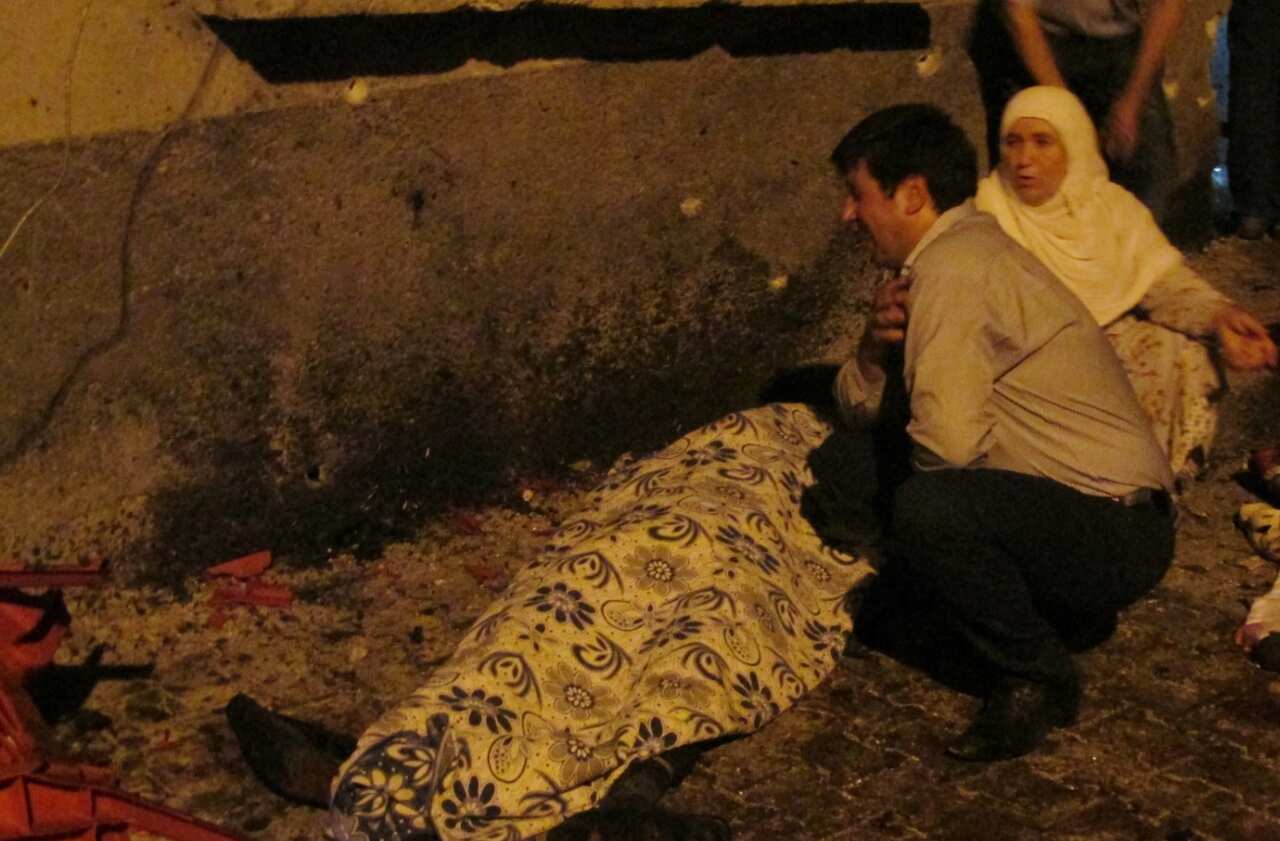 A man cries over a covered body after an explosion in Gaziantep, southeastern Turkey