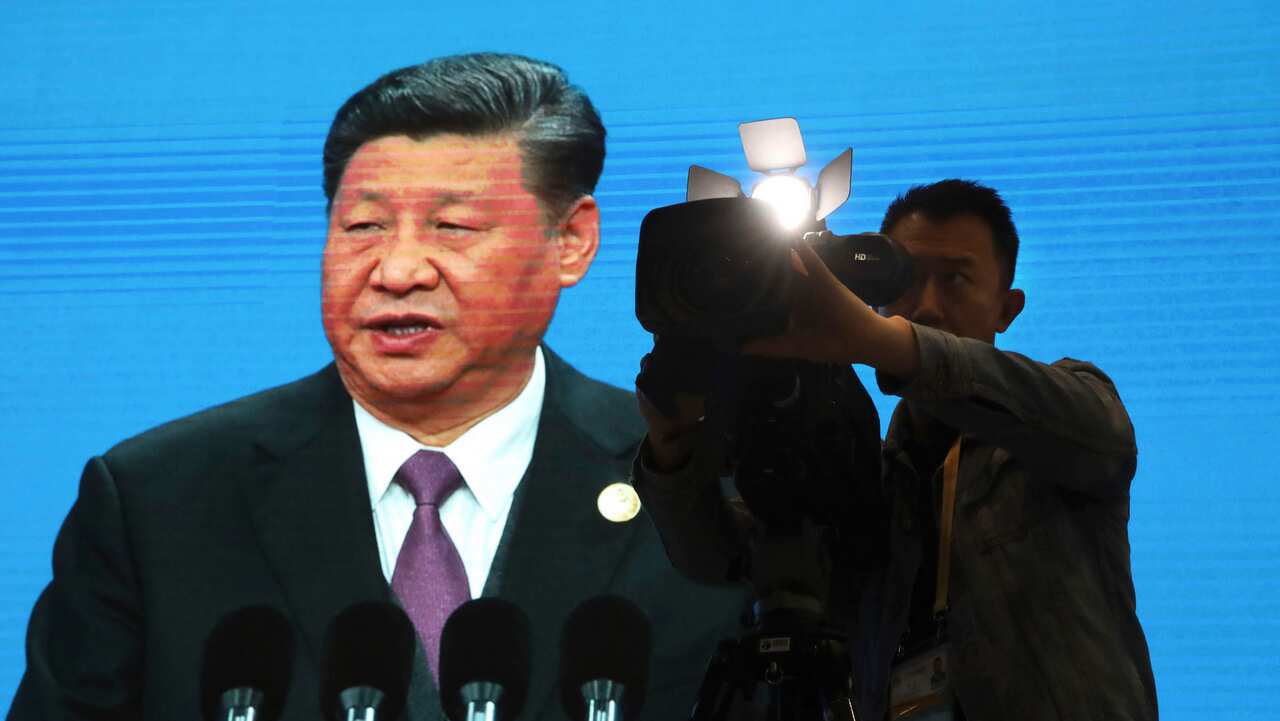A cameraman films near a screen live broadcasting Chinese President Xi Jinping opening the Second Belt and Road Forum.